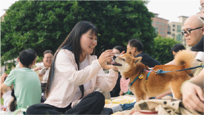 戀愛好事多辦的聯誼交友活動，有女參加者與寵物在戶外草地野餐，聊天互動，享受輕鬆溫暖的活動氛圍。 